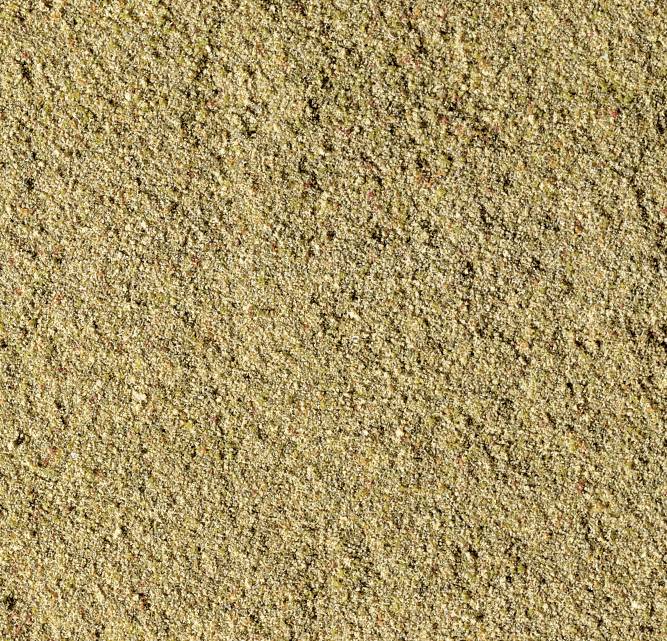Nærbillede af våd sand med fin, kornet struktur fordelt i forskellige nuancer af brun.