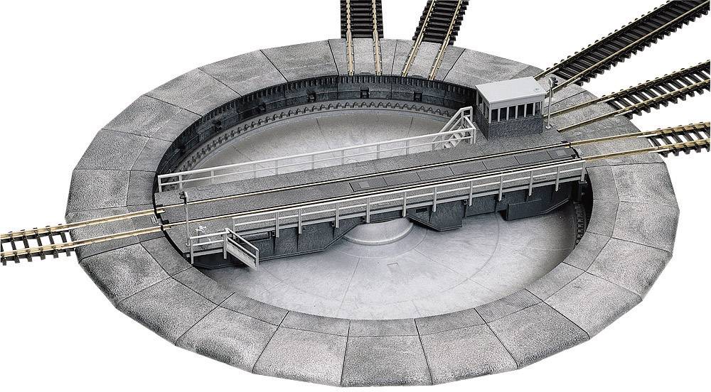 Drejeskive til et modeljtog med flere skinnespor. En platform med rækværk drejer rundt i centrum.