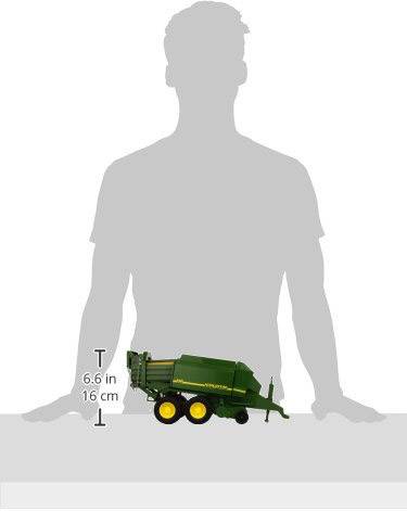 En legetøjsmodel af en landbrugsvogn på et bord, omtrent 16 cm høj, står foran en persons skyggekontur.