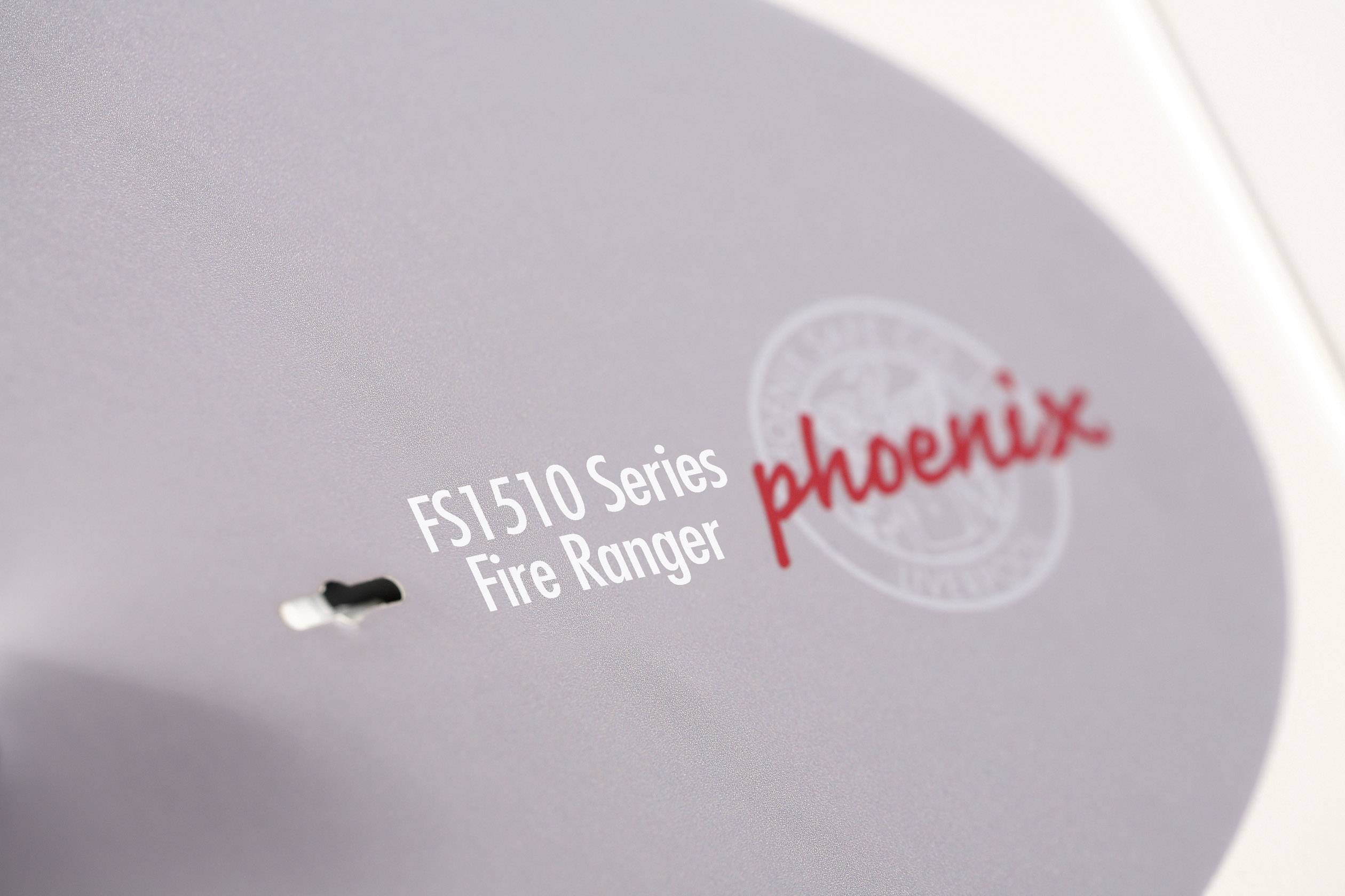 Nærbillede af en del af et produkt med påskriften 'FS1510 Series Fire Ranger' og 'phoenix' i røde bogstaver.