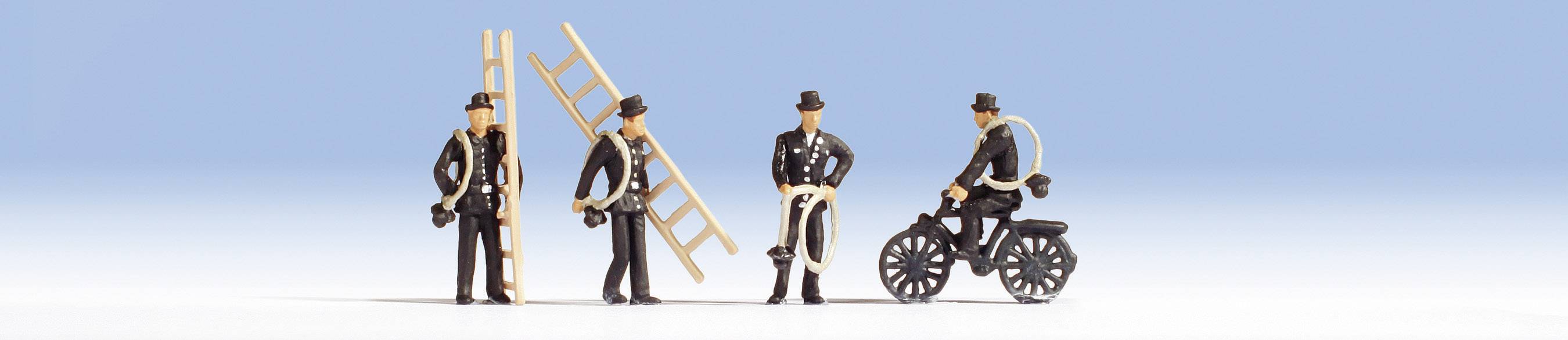 Fire miniaturfigurer af skorstensfeiere på blå baggrund: En bærer en stige, to står og taler sammen, en sidder på en cykel.