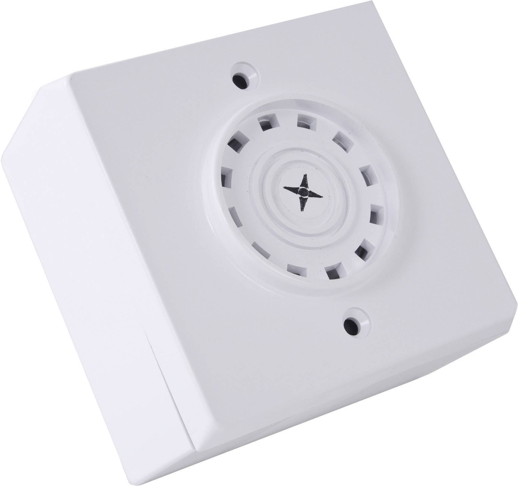 En hvid røgalarm med ventilationsåbninger og et centralt stjernesymbol, monteret på en hvid overflade.