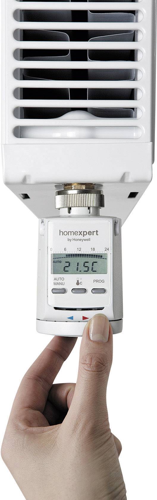Hånd drejer termostat på hvid radiator til 21,5 °C. Digitalskærmen viser temperaturen.