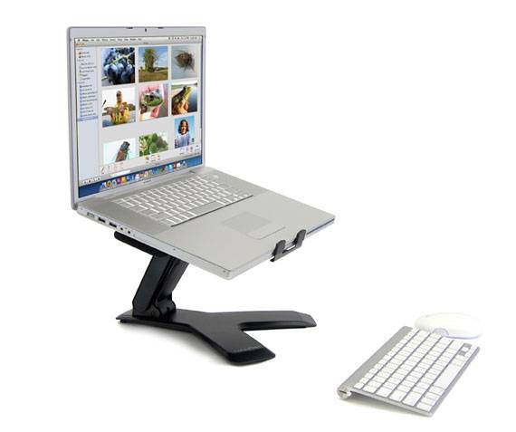 En bærbar computer på en højdejusterbar stander viser et fotogalleri på skærmen. Ved siden af ligger et tastatur og en mus.