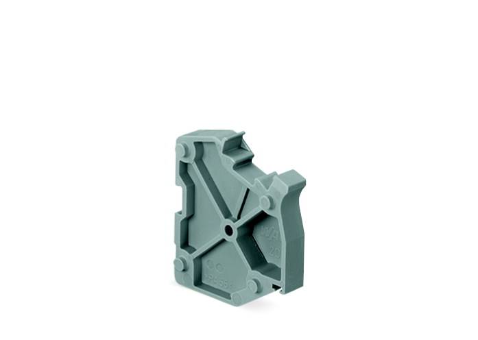 Grå, plastisk genstand med geometriske former og forhøjninger, står lodret op mod en hvid baggrund.