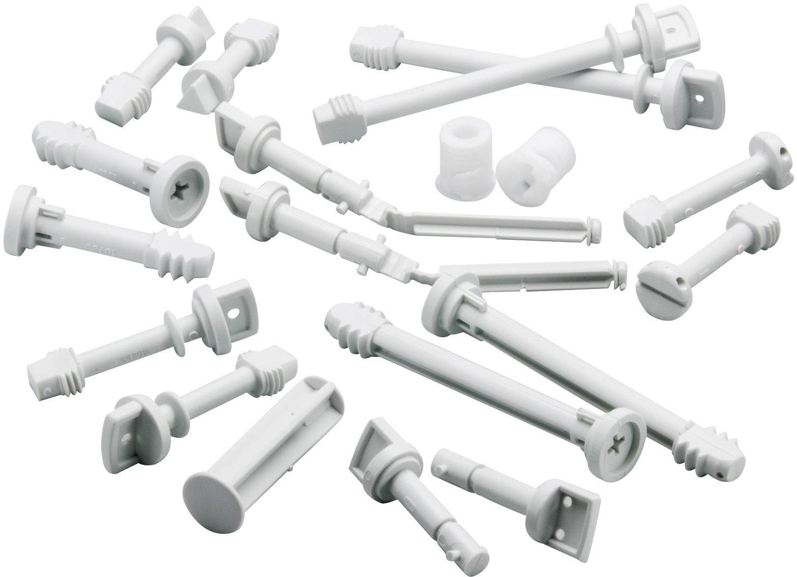 Flere hvide plastic rawlplugs i forskellige størrelser og former, spredt ud på en hvid baggrund.