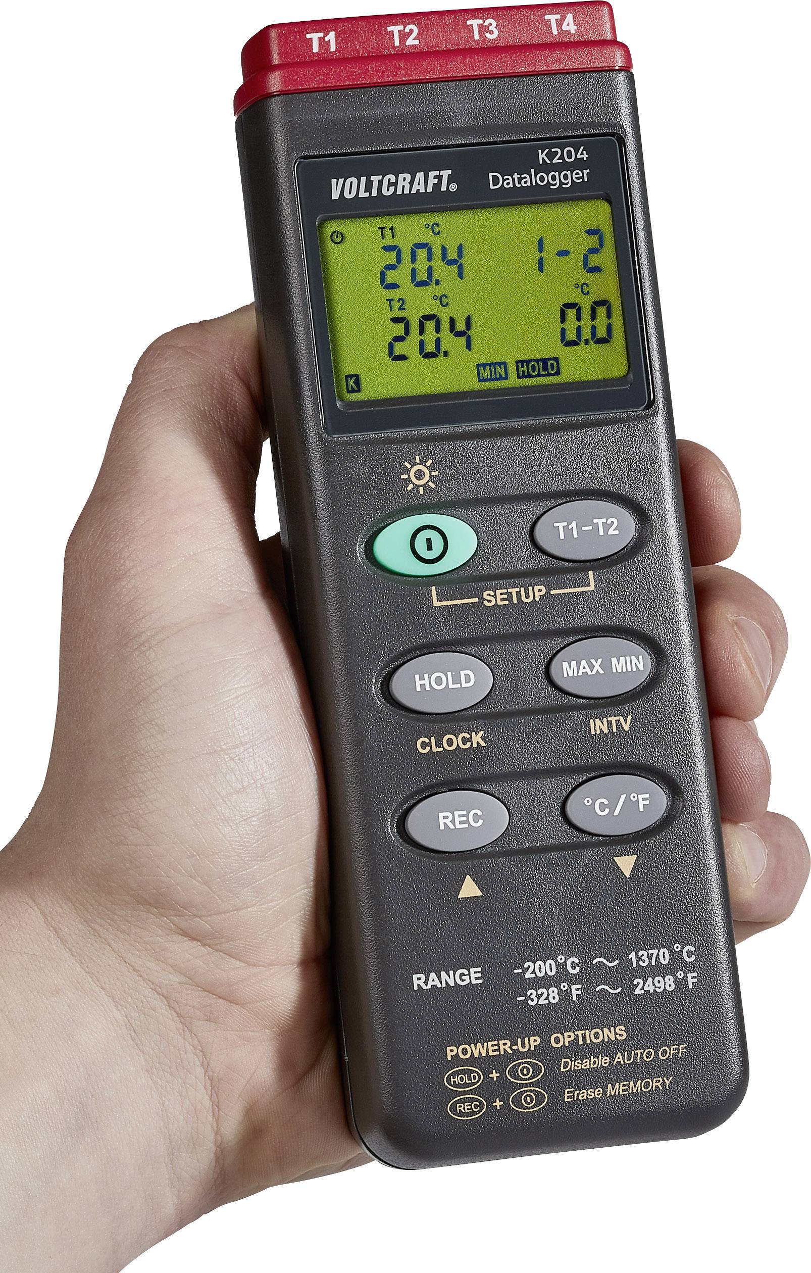 Hand hält digitalen Voltmeter mit mehreren Knöpfen und Display, zeigt Temperaturmessungen in Celsius, Markenname 'Voltcraft'.