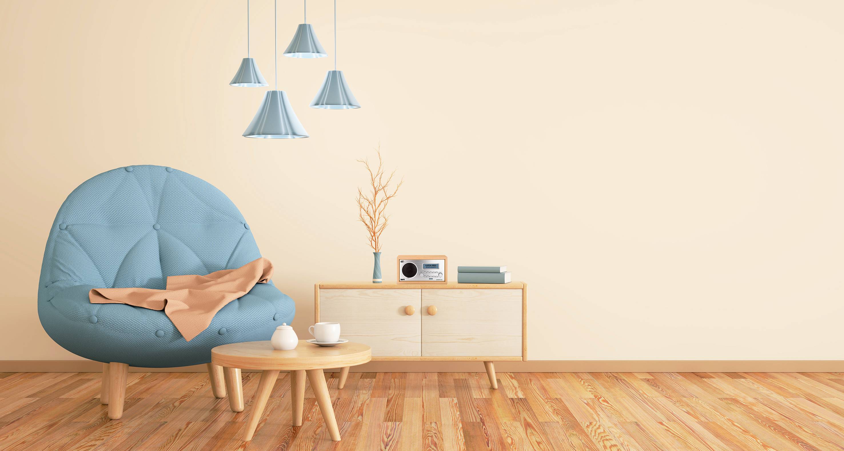 Blaugrüner Sessel mit beiger Decke daneben, kleiner Holztisch mit Tasse, Teller; moderne Hängelampen, Holzkommode mit Deko.