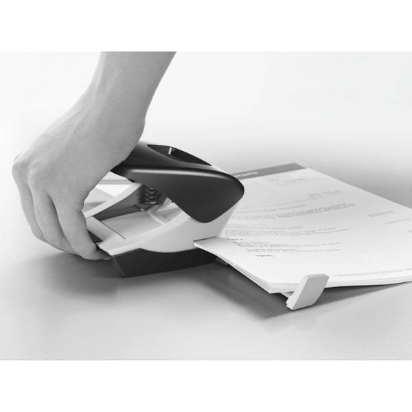 Eine Hand benutzt einen Heftapparat, um Dokumente zu heften. Der Heftapparat ist schwarz-weiß, und die Dokumente liegen auf einem Tisch.