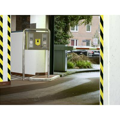 Parkhaus-Einfahrt mit Schranke und Ticketautomat. Im Hintergrund Bäume und Ziegelgebäude. Verkehrszeichen sichtbar.