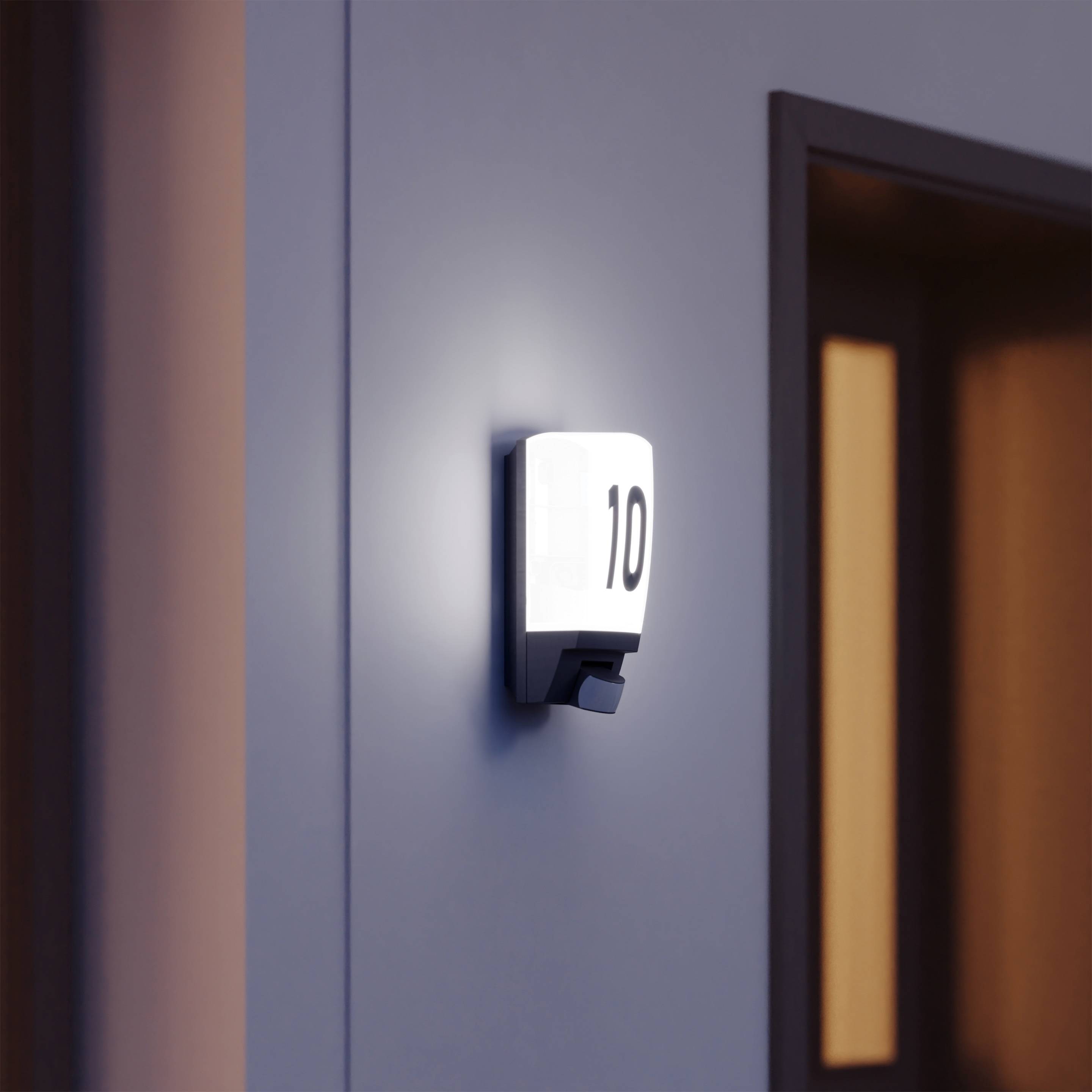 Eine leuchtende Zimmernummer '10' an einer Wand, neben einem Türrahmen.
