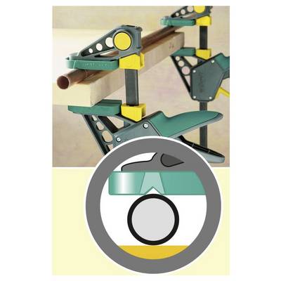Eine Klemmvorrichtung sichert ein Holzstück, wobei eine Einblendung den Mechanismus zeigt und verstellbare Komponenten in Gelb und Grün hervorhebt.