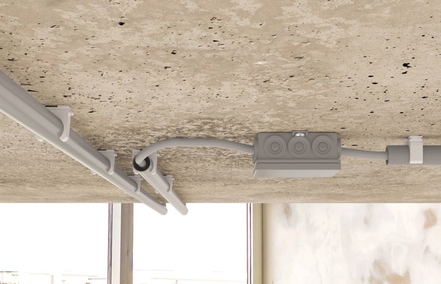 An der Decke montierte elektrische Kabelkanäle und Verteilerdose installiert gegen eine Betondecke in der Nähe eines Fensters.
