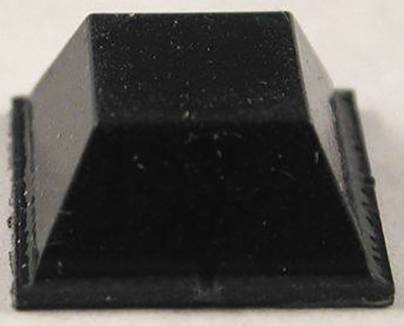 Ein schwarzes, quadratisches, pyramidenförmiges Objekt mit flacher Basis auf einer hellen Oberfläche.