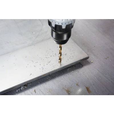 Eine Bohrmaschine bohrt ein Loch in eine Metallplatte. Metalspäne sind auf der Oberfläche verstreut.