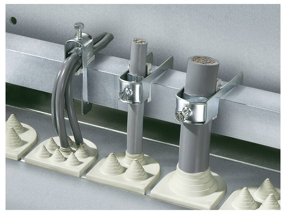 Beschriftung zeigt Kabel und Rohre, die mit Metallklemmen an einer Schiene befestigt sind. Kunststoffelemente dichten die Durchführungen ab.