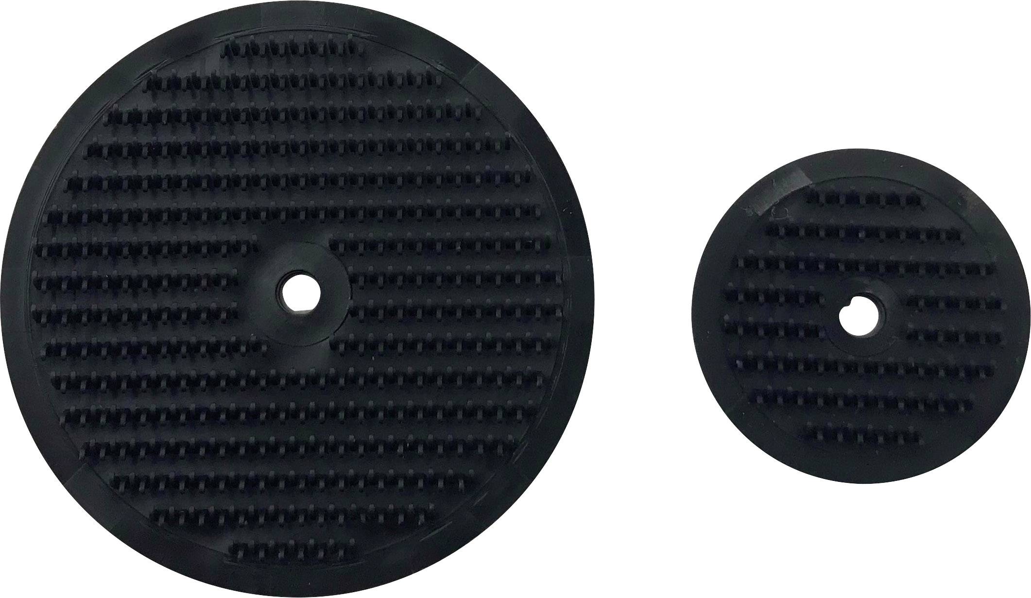 Zwei schwarze, runde Gummischeiben mit strukturierten Oberflächen, die nebeneinander liegen. Links eine größere, rechts eine kleinere Scheibe.