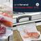 'NovaVac PRO 310' von profibrand, ein Vakuumiergerät. Links frischer Lachs und Rindfleisch in Vakuumbeuteln. Ideal für Konservierung.