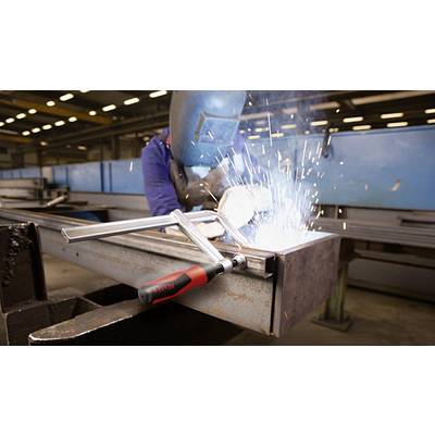 Ein Schweißer arbeitet mit Schweißgerät an einem Metallträger in einer Fabrikhalle. Funken sprühen um den Arbeitsbereich.