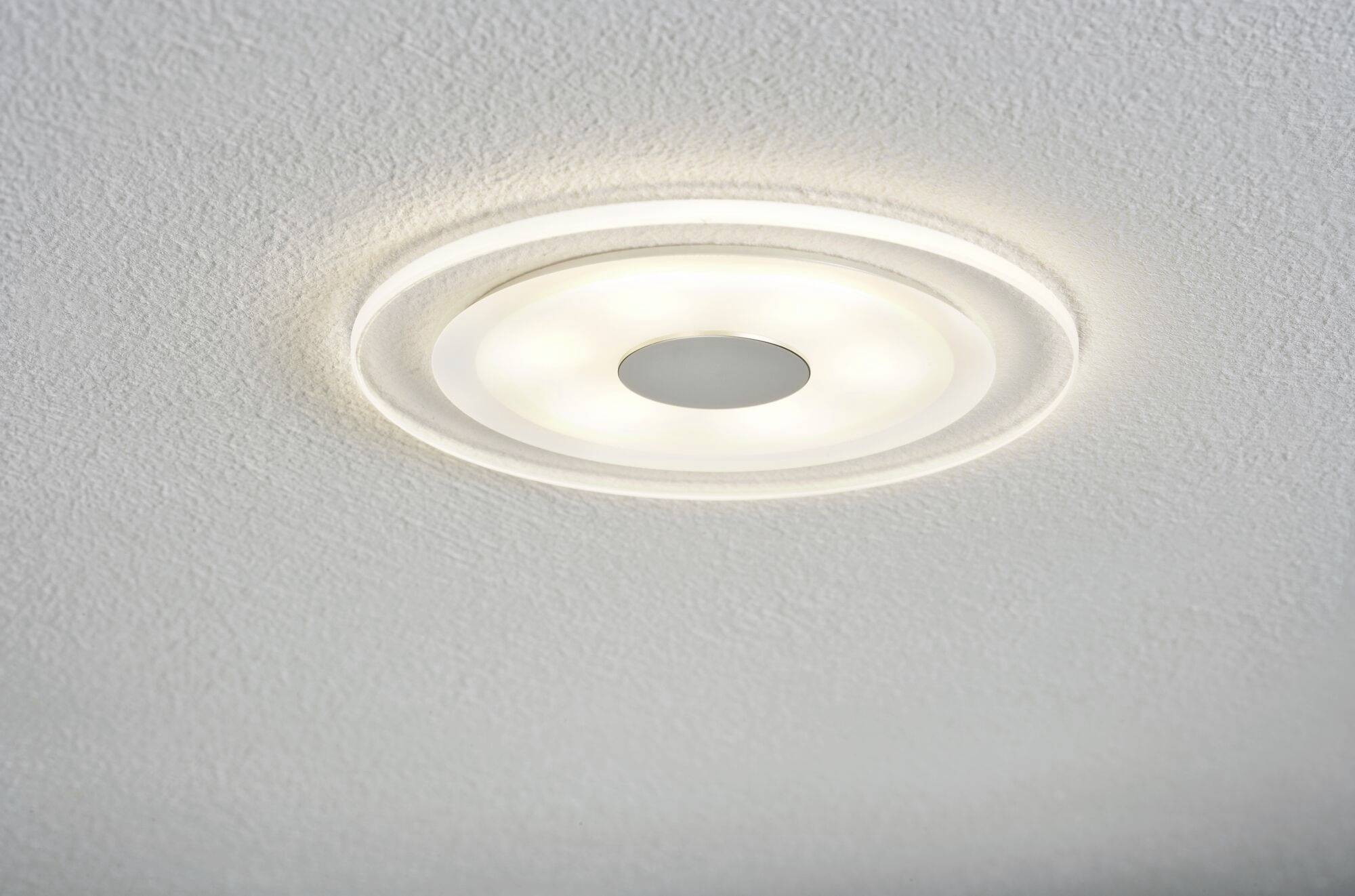 Deckenleuchte mit runder Form und mehreren LED-Leuchten, die eine weiche Beleuchtung auf die umliegende weiße Decke werfen.