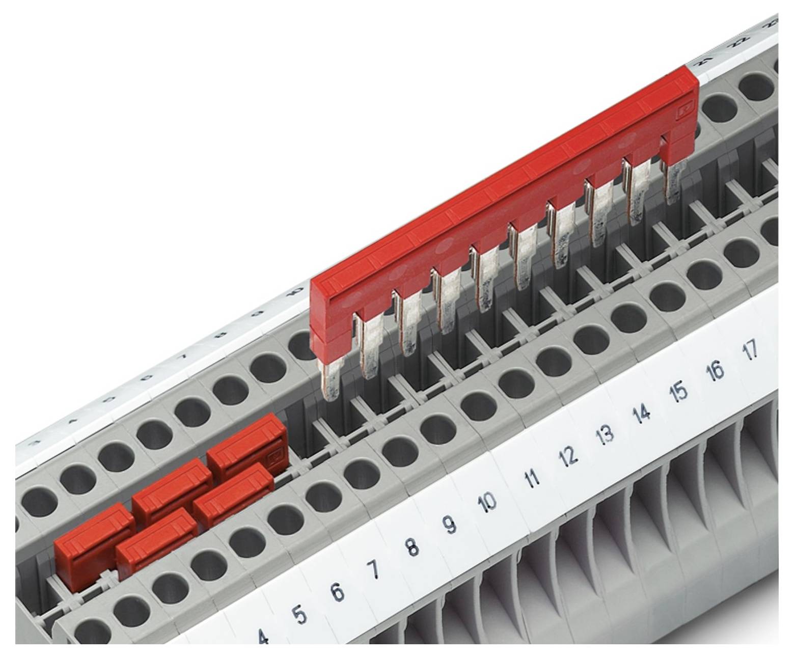 Ein Klemmenblock mit einem angeschlossenen roten Verbindungssteg und nummerierten Slots, der einen Teil eines elektrischen oder Verdrahtungssystems zur Organisation zeigt.