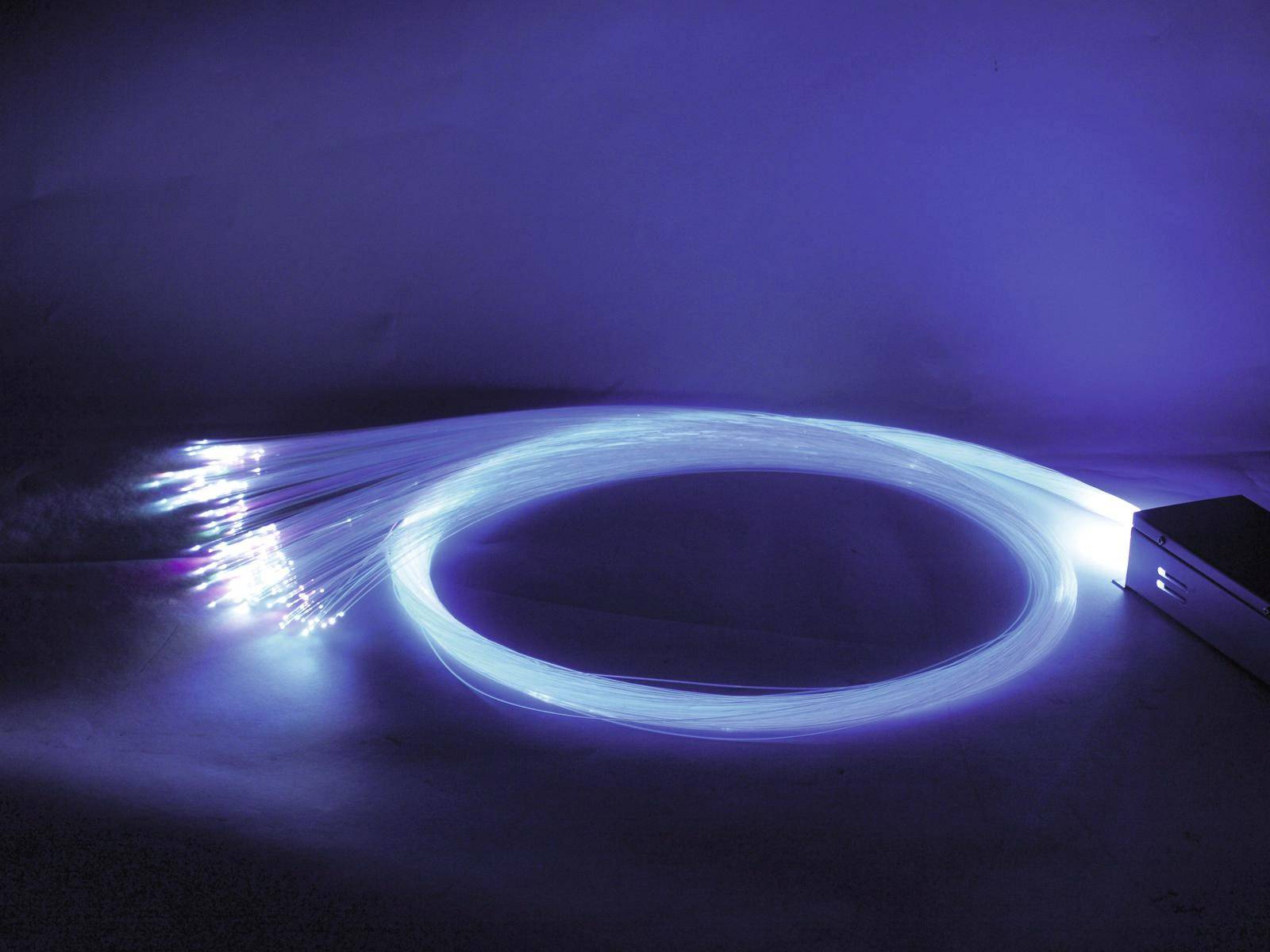 Glühende Glasfaserkabel in Blau formen einen Kreis. Lichter strahlen von den Kabelenden aus.