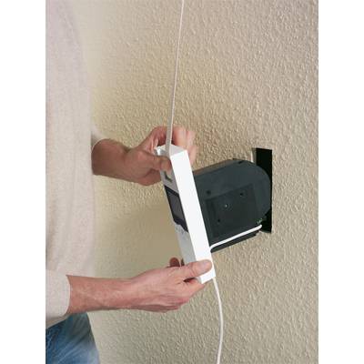 Eine Person installiert ein weißes Thermostat an der Wand, indem sie es an einen bereits eingebauten schwarzen Kasten anschließt.