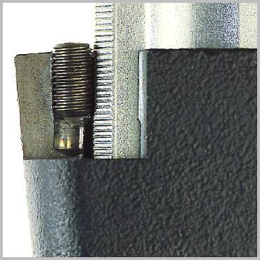 Nahaufnahme eines Maschinenteils mit Schraube und metallischen Oberflächen. Das Teil zeigt präzise gefertigte Details.
