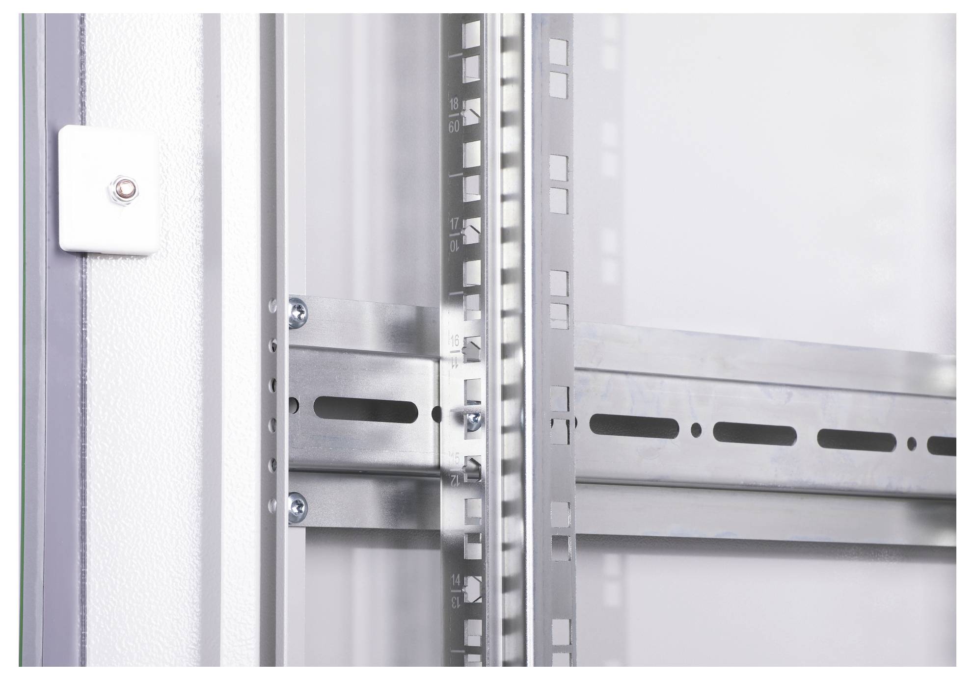 'Detailaufnahme eines Schienensystems an einer weißen Wand, das Metallregale unterstützt. Deutliche Schrauben und Halterungen sichtbar.'