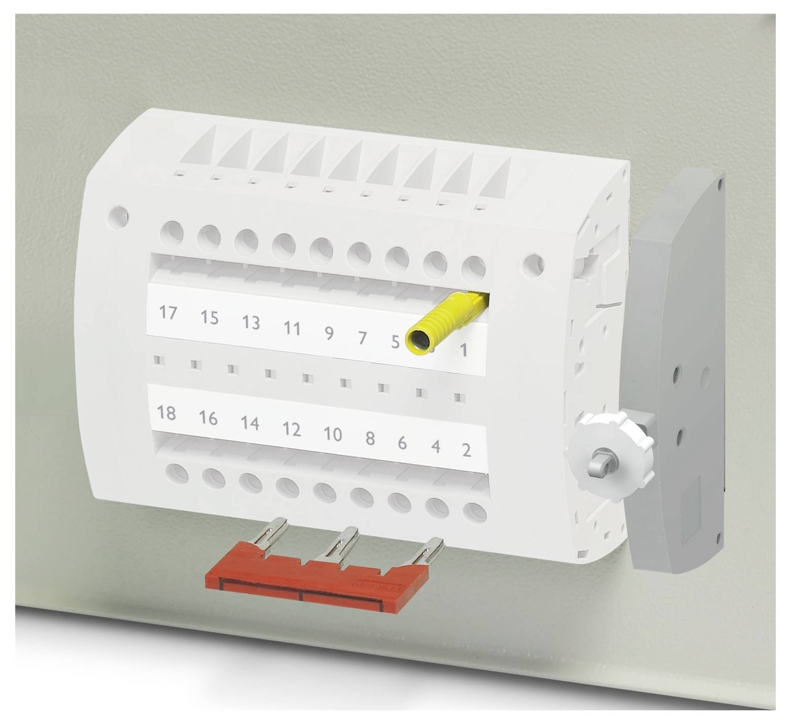 Weißes Elektroklemmenblock mit mehreren Anschllusspunkten, mit den Nummern 1-18 gekennzeichnet, mit einem gelben Draht an Position 7 eingeführt.