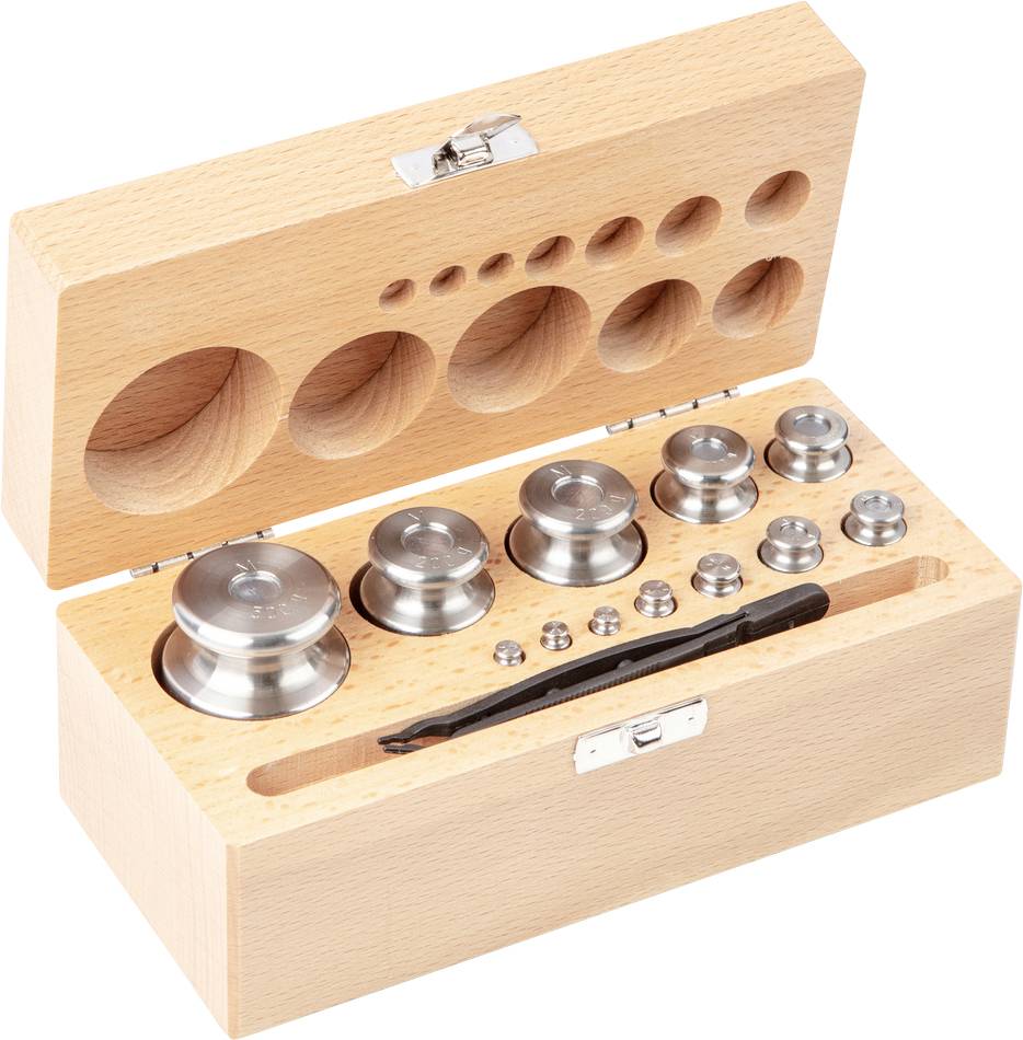 Eine Holzkiste enthält ein Set aus Chrom-Gewichten in verschiedenen Größen und einer Pinzette, ausgelegt für präzises Wiegen.