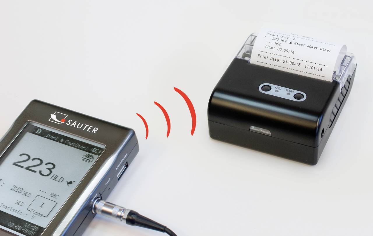 Ein digitales Gerät zeigt '223 HLD', verbunden mit einem kleinen Drucker. Rote Wellenlinien symbolisieren drahtlose Datenübertragung.