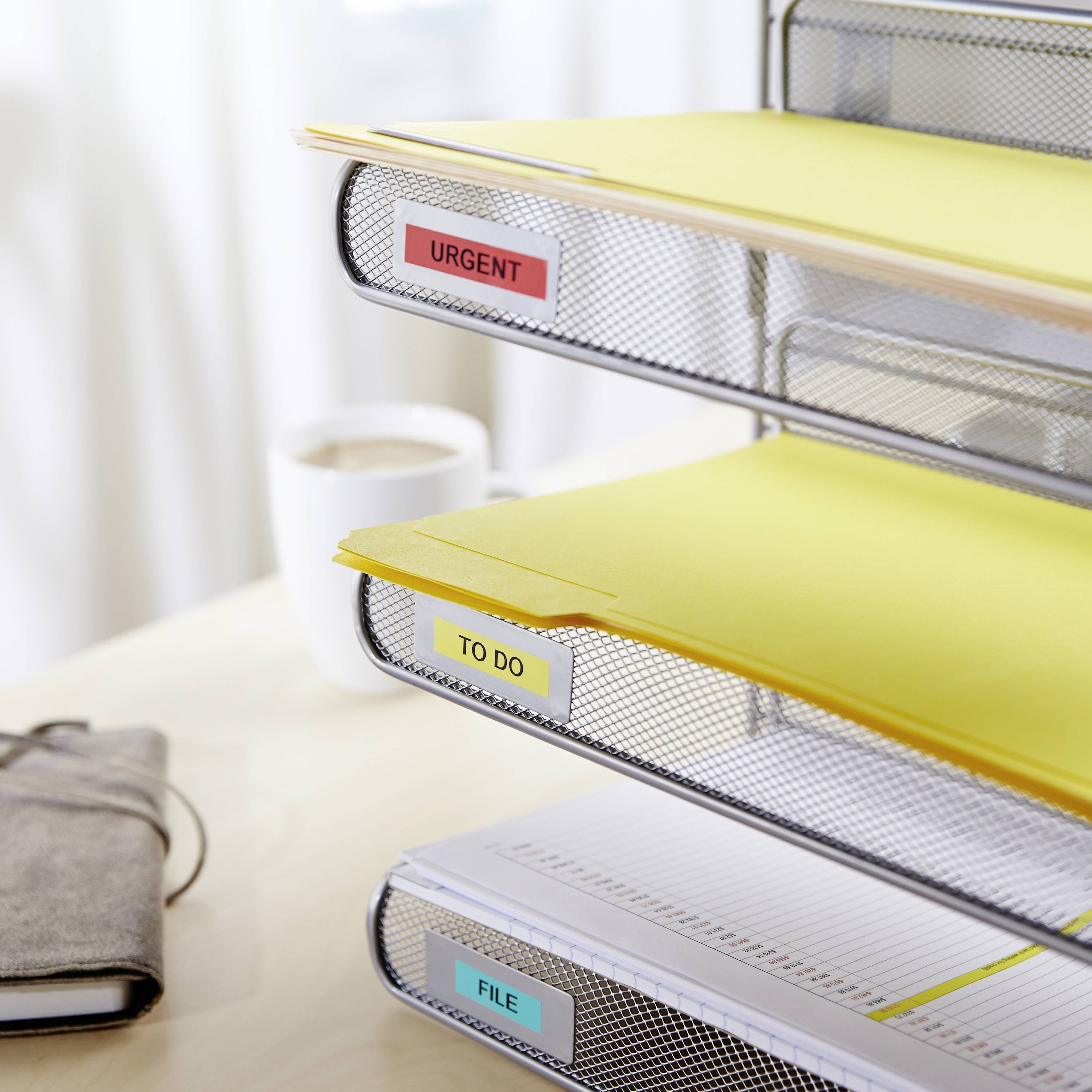 Ein Schreibtisch-Ablagesystem mit drei Fächern. Oben sind Ordner mit der Bezeichnung 'URGENT', in der Mitte 'TO DO', unten 'FILE'.