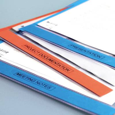 'Dokumentenmappen mit Labels: "Präsentation", "Projekt-Dokumentation" und "Besprechungsnotizen", auf einem Tisch liegend.'