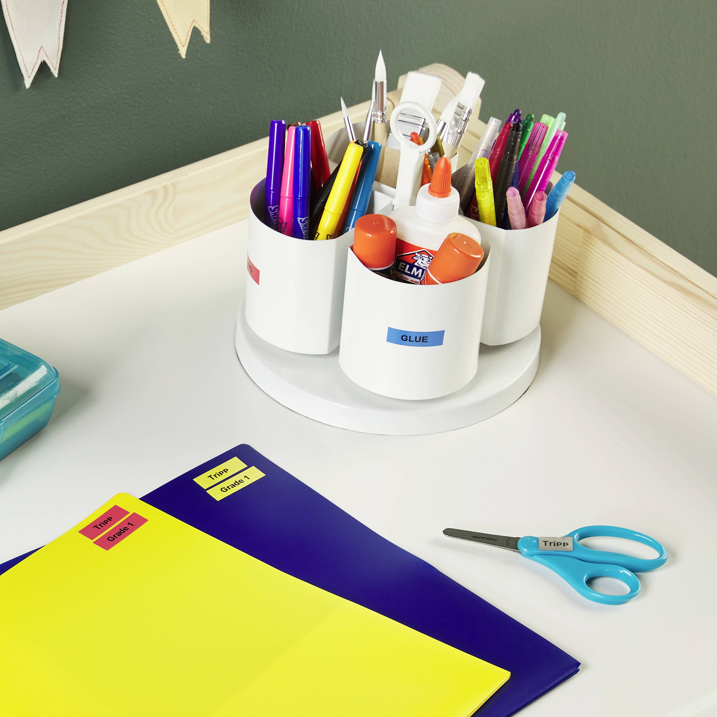 Ein Schreibtisch mit Stiften, Schere und Kleber in einem Halter; daneben Dateien und ein Lineal, symbolisiert Büroorganisation.