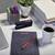 Ein Schreibtisch mit Laptop, Stiften, Pflanze, Taschentücherbox, Kaffeetasse und Notizbuch mit rotem Stift, typisches Büro-Setup.