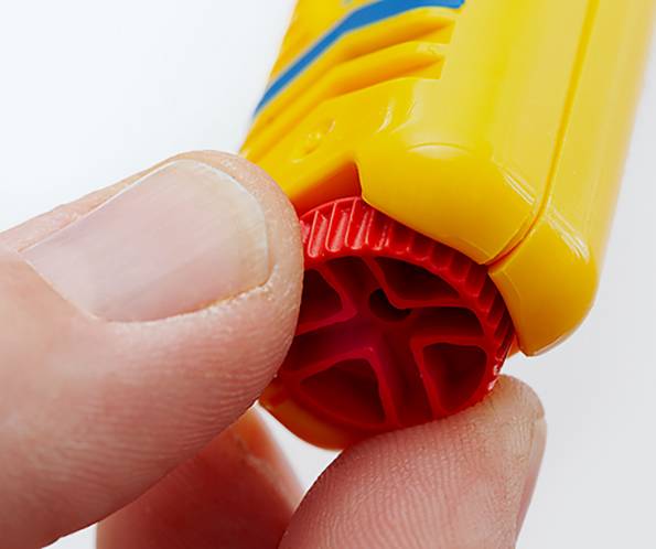 Eine Nahaufnahme von Fingern, die einen roten Drehknopf an einem gelben Plastikgerät justieren, möglicherweise ein Spielzeug oder Werkzeug, die den Fokus auf das detaillierte Design und die Funktion legt.