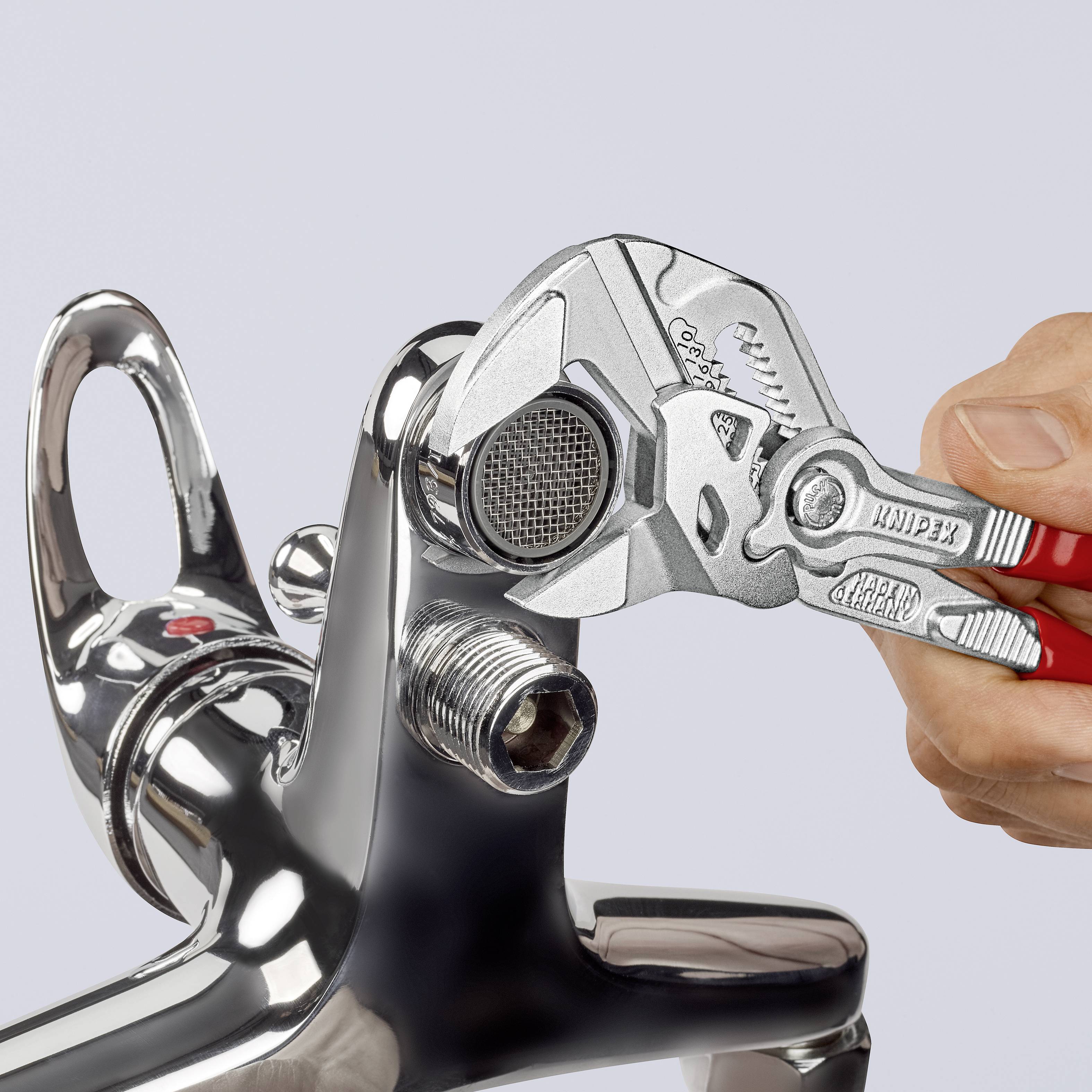 'Eine Hand benutzt eine Zange, um einen Wasserhahn zu reparieren, auf grauem Hintergrund.'