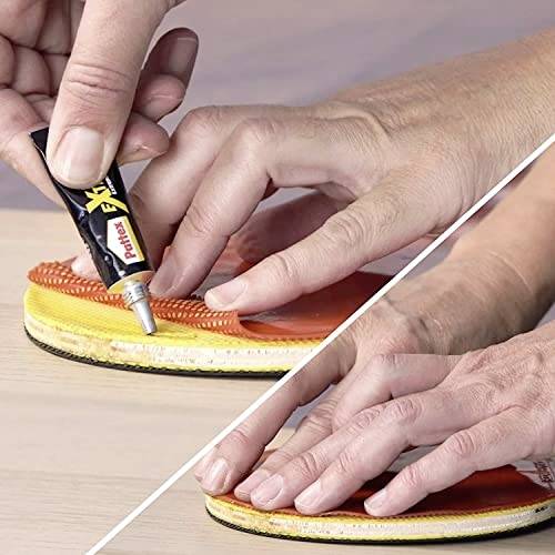 Hand, die Klebstoff auf eine Schuhsohle aufträgt; dann wird Sohle und Schuh fest zusammengedrückt.