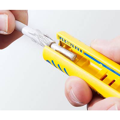 Eine Nahaufnahme von Händen, die einen gelben Abisolierwerkzeug verwenden, um die Isolierung von einem Kabel zu entfernen und dabei die inneren Metallstränge freizulegen.