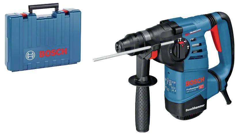 Akku-Bohrmaschine auf rostigem Metallkettenglied auf einer Baustelle stehend, mit unscharfen Baggern im Hintergrund.