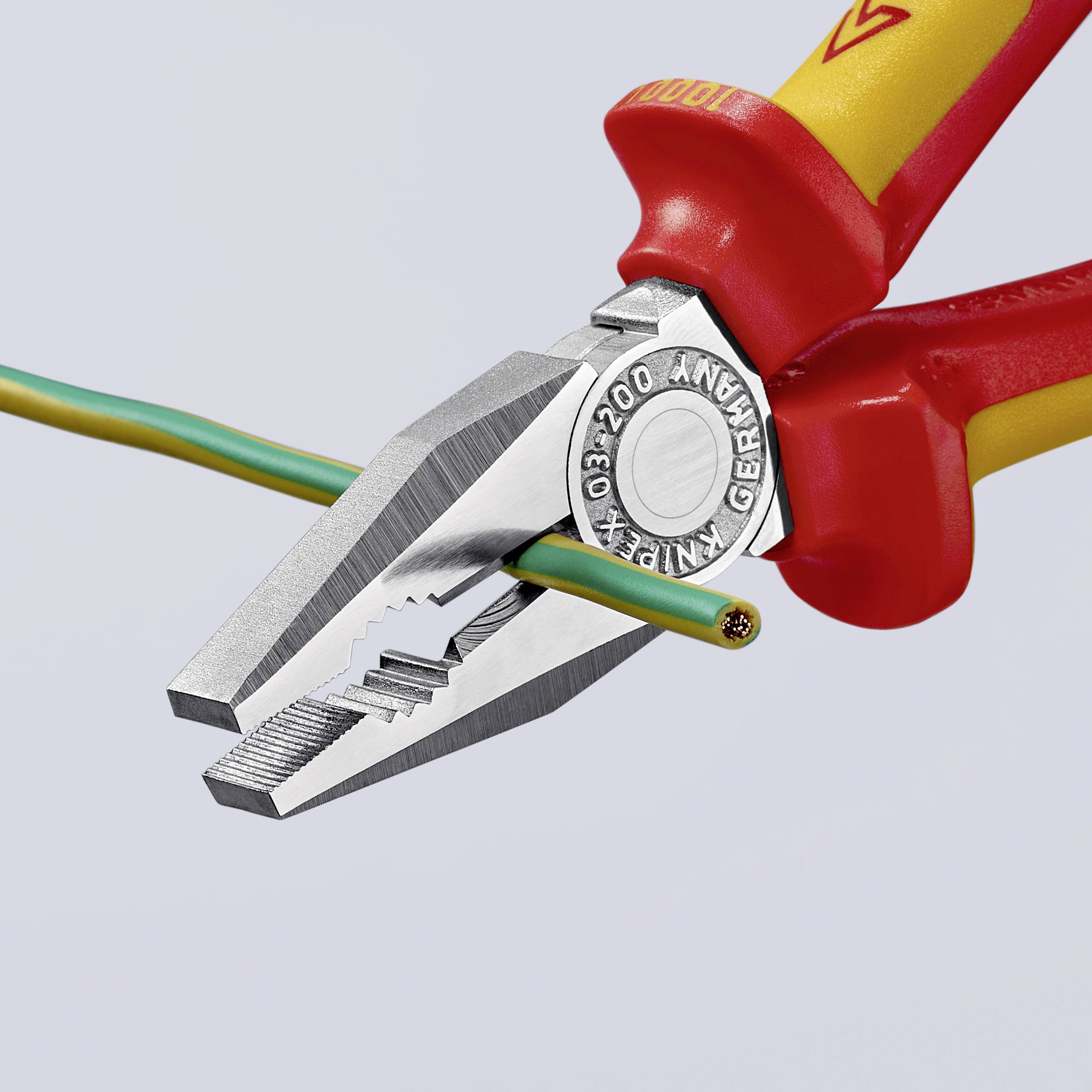 Eine rote Kombizange schneidet durch ein zweifarbiges Kabel, was hauptsächlich für elektrotechnische Arbeiten genutzt wird.