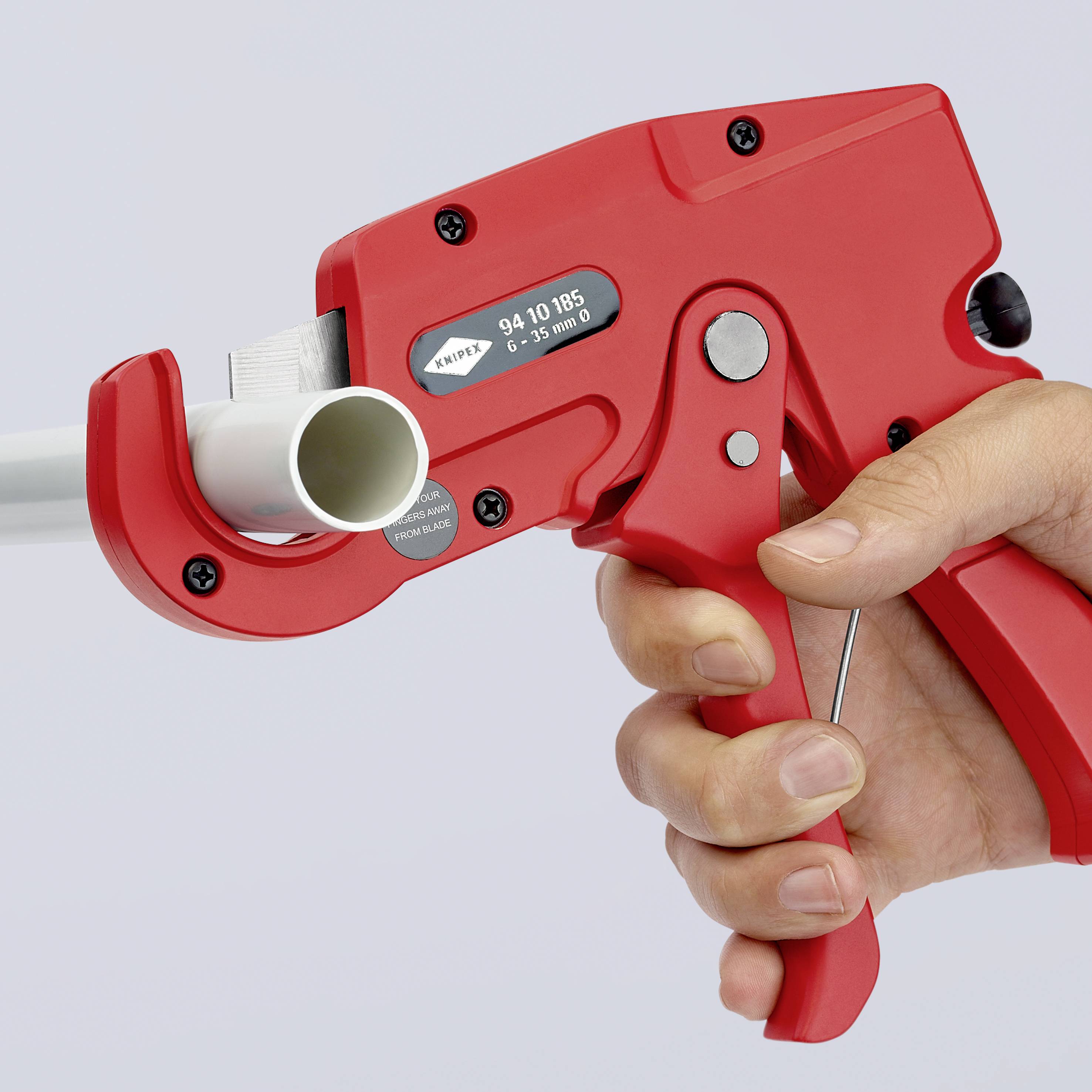 Eine rote Handpresse, die ein weißes Rohr crimpt. Eine Hand hält den Griff, während die andere das Werkzeug bedient.