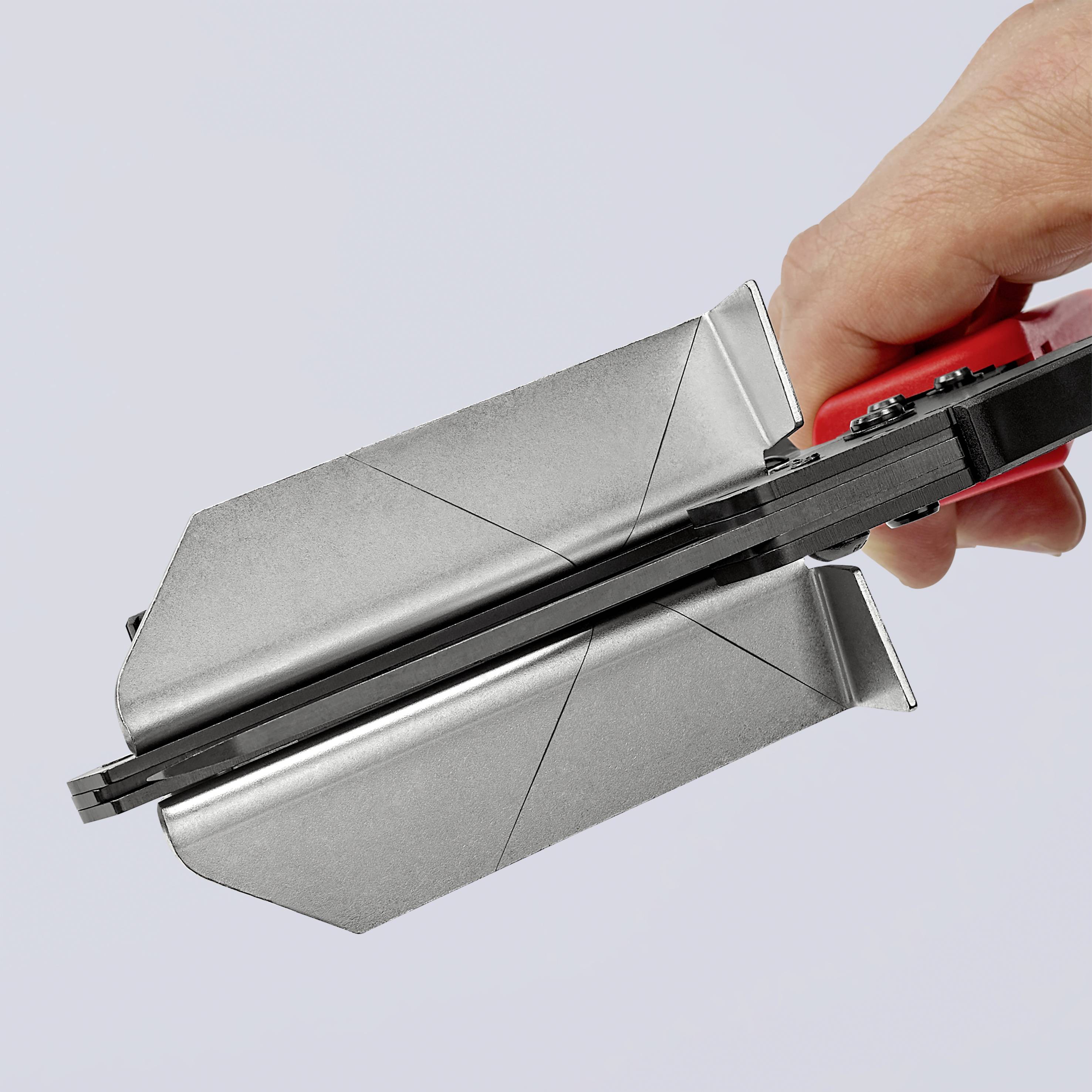 Eine Hand hält eine Silberschachtel, die, geöffnet, einen roten Mechanismus oder Hebel zeigt.