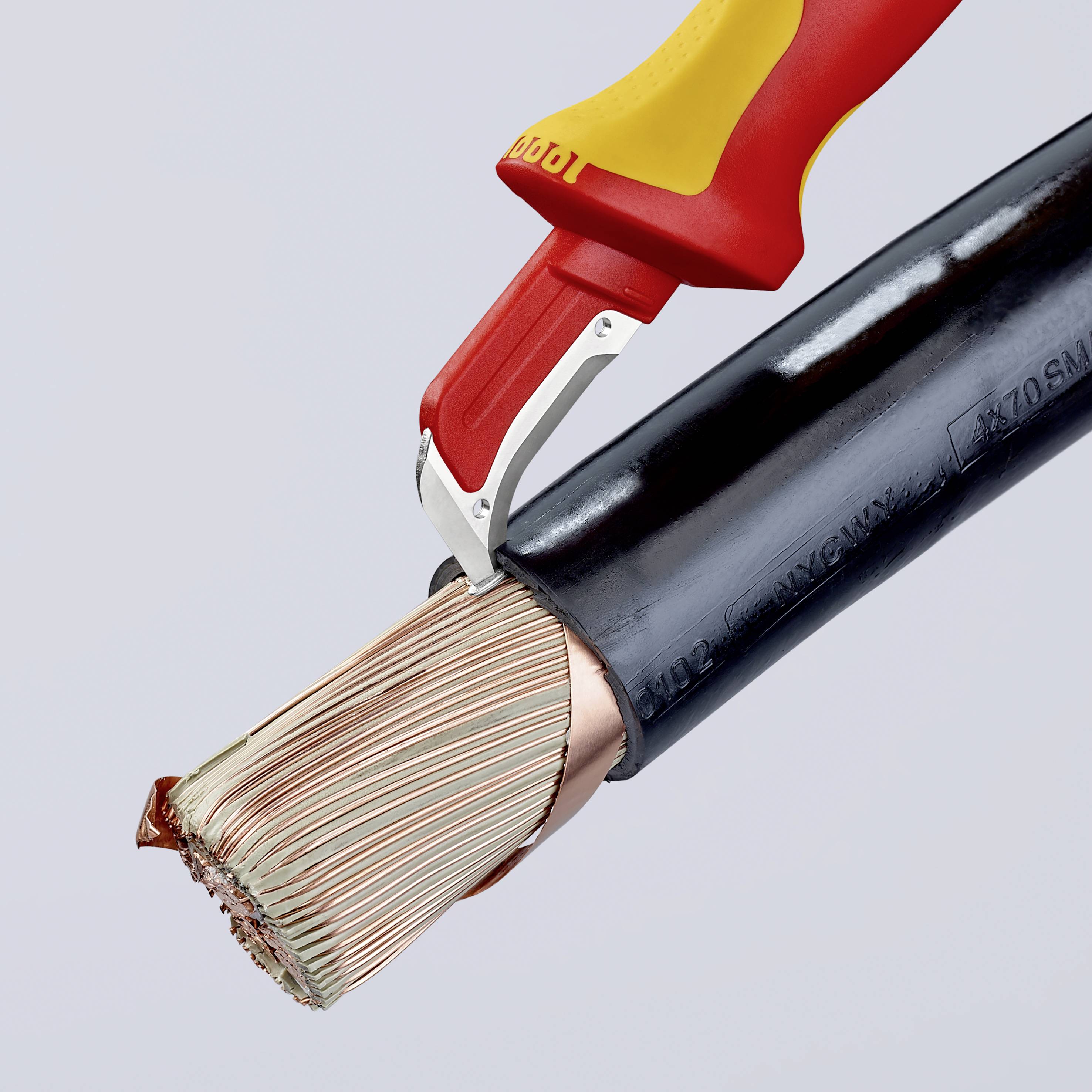 Ein Werkzeug schält das Ende eines elektrischen Kabels ab, wobei die Kupferdrähte zum Vorschein kommen.