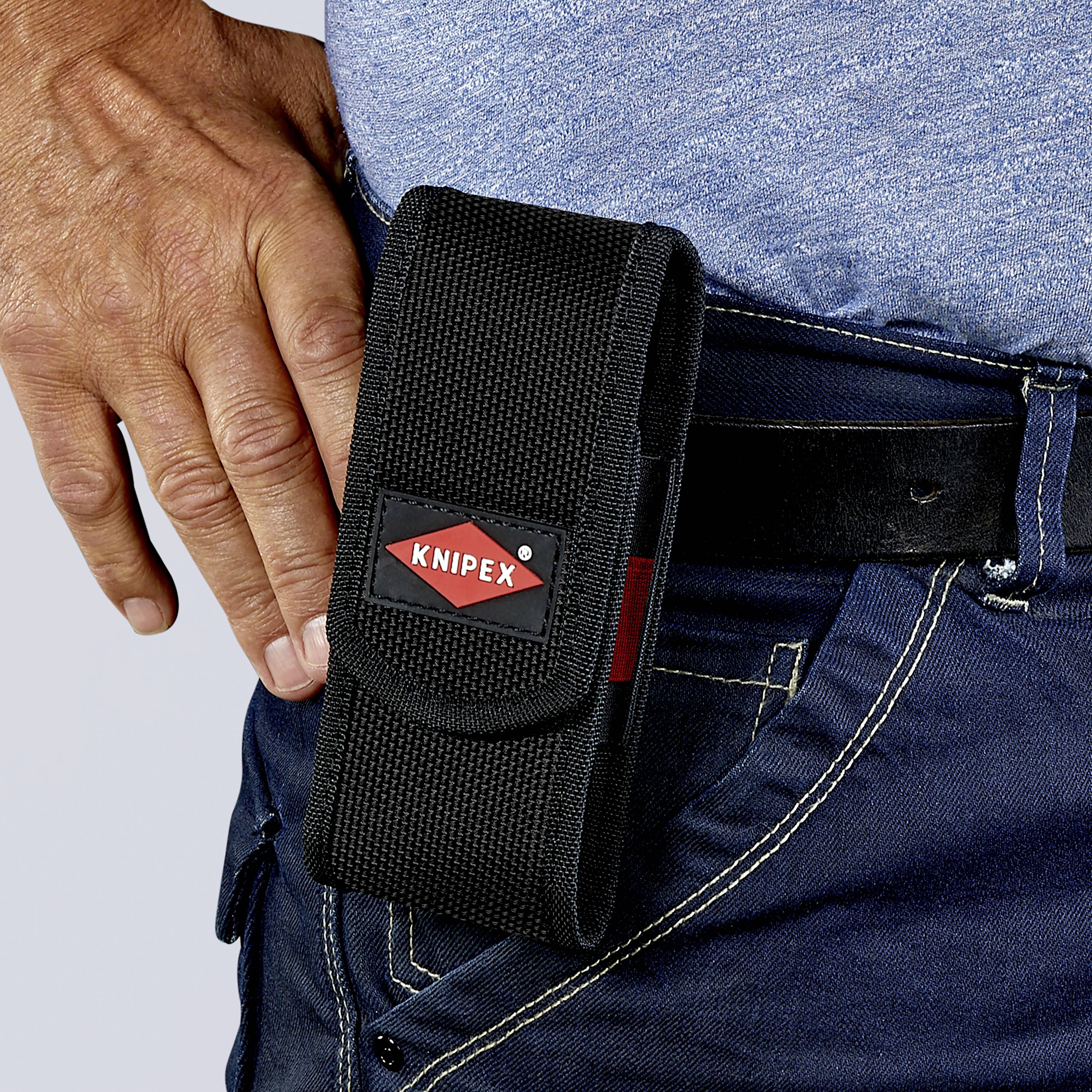 Eine Hand trägt eine blaue Jeans mit einem schwarzen Gürtel. Eine schwarze KNIPEX-Werkzeugtasche ist am Gürtel befestigt.