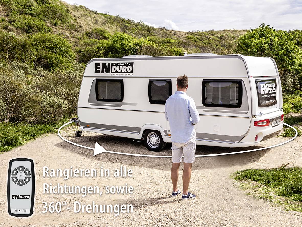 Ein Mann steht neben einem Wohnwagen, umgeben von hügeliger Landschaft. Text: 'Rangieren in alle Richtungen sowie 360° Drehungen'.