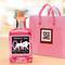 Eine rosa Ginflasche mit Hundelogo und 'Premium Pink Dry Gin 4% vol. made in Bavaria' steht vor einer rosa Geschenkverpackung mit QR-Code.
