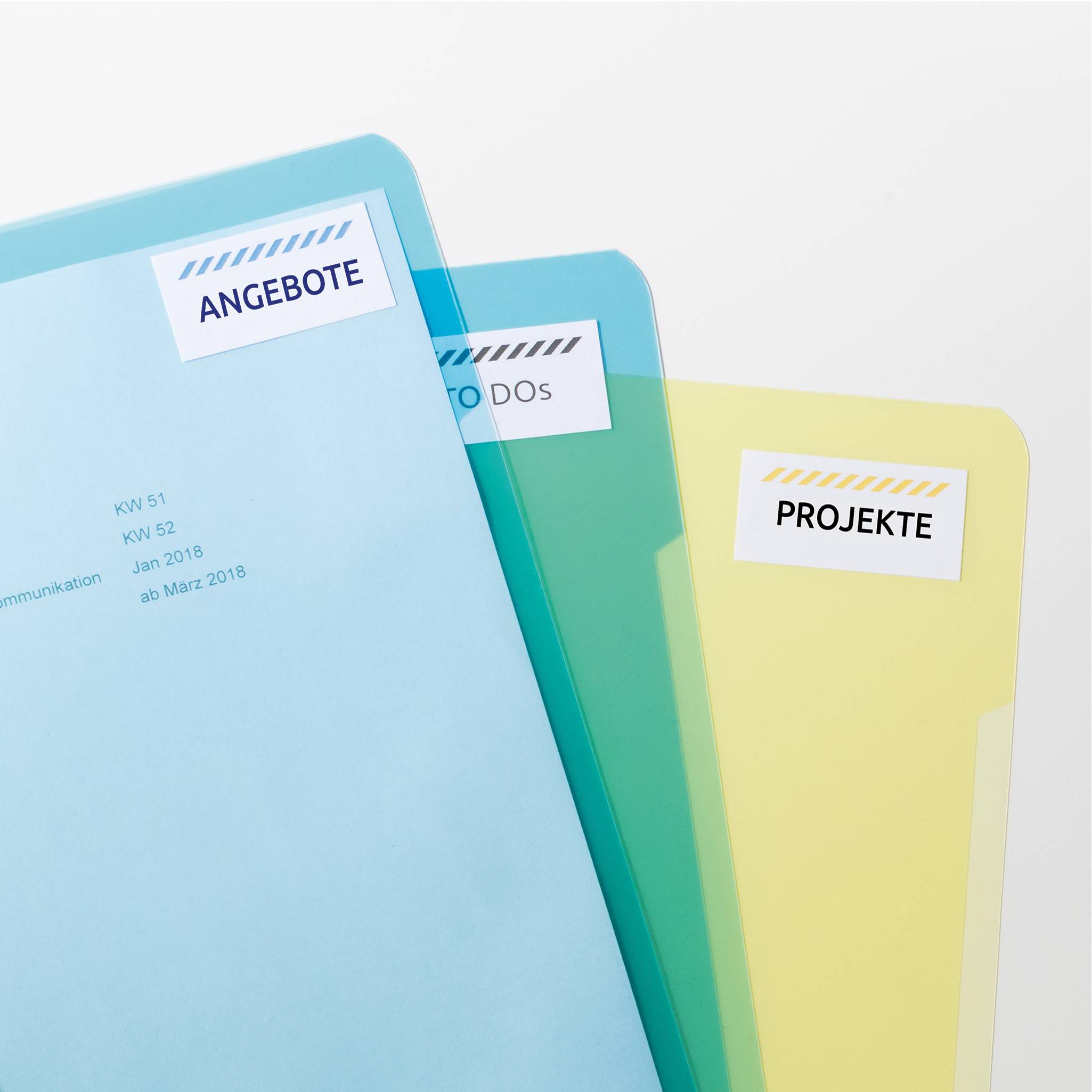 Drei farbige Ordner mit Etiketten: 'ANGEBOTE' (blau), 'TO DOs' (grün) und 'PROJEKTE' (gelb). Sie stehen leicht versetzt nebeneinander.