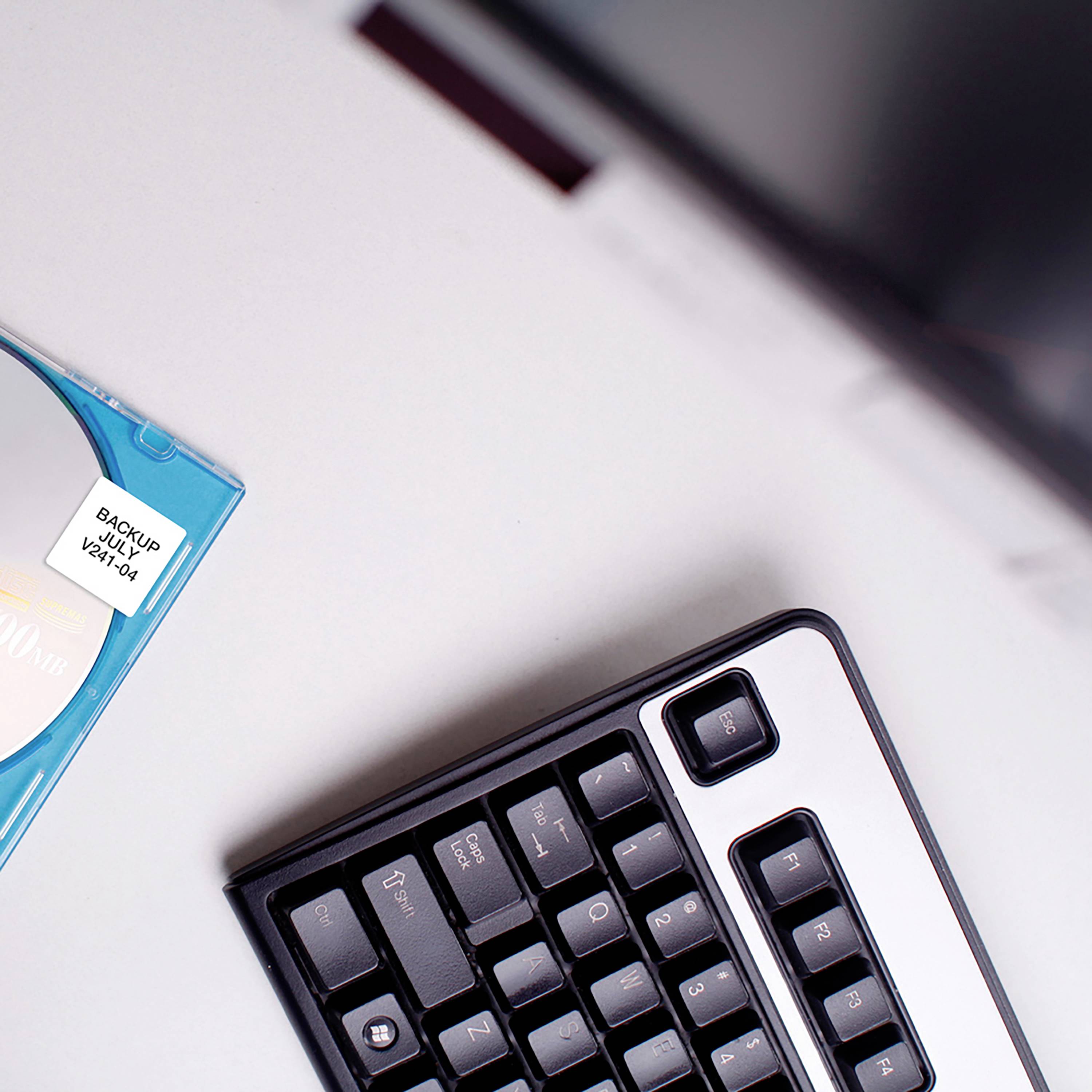 Eine CD mit der Aufschrift 'Backup Archive 202004' liegt neben einer Computertastatur auf einem Tisch.